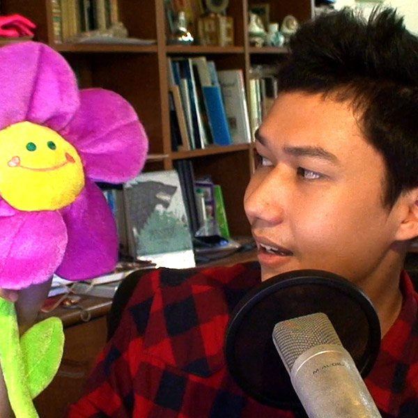 GamerZakh looking at a plush pink flower.